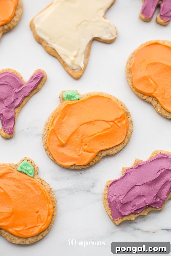 Several paleo Halloween cookies, including a bat and a ghost, presented on a rustic wooden board, ready for Halloween festivities.