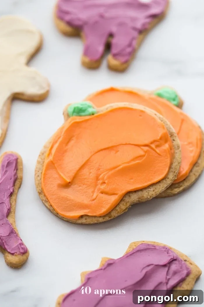 A top-down view of beautifully decorated paleo Halloween cookies, showcasing different festive shapes and colors, perfect for a party.