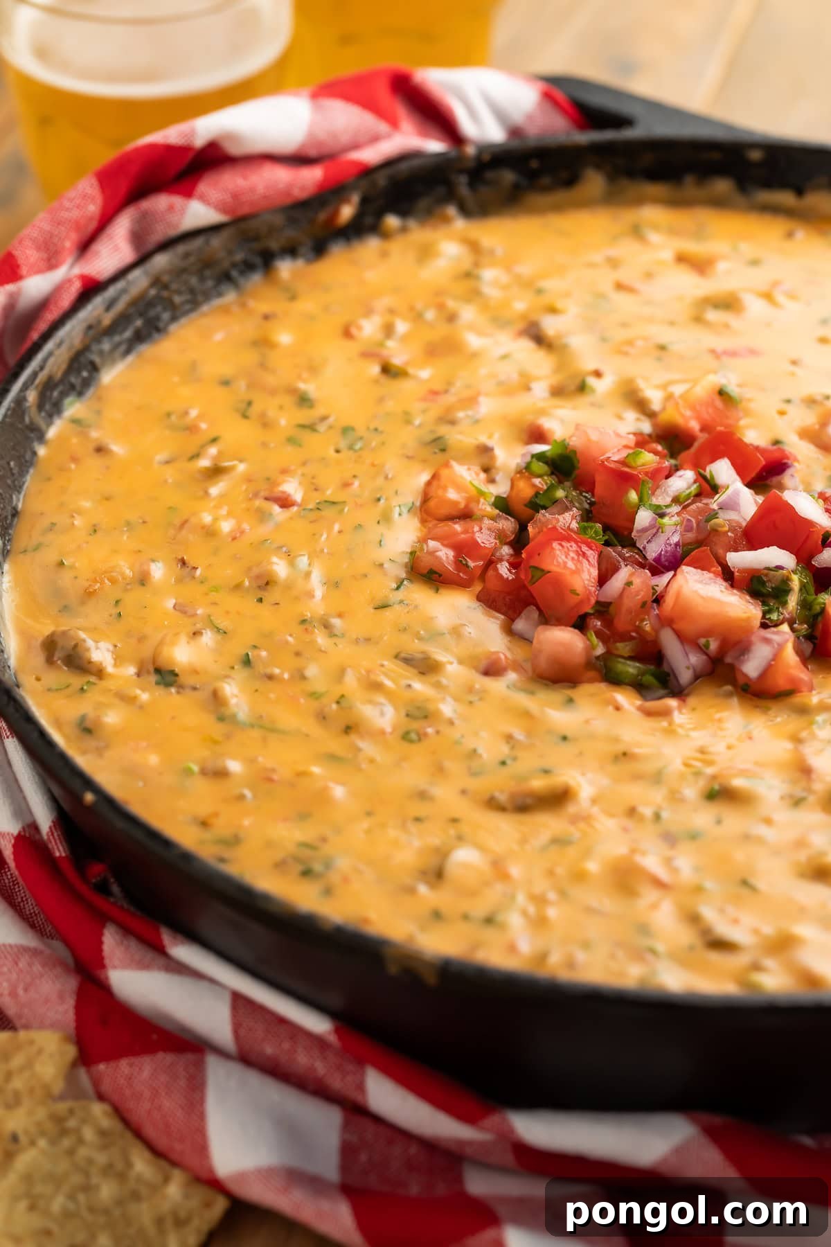 Ingredients for smoked queso recipe including cubed American cheese, browned ground sausage, Rotel diced tomatoes, chopped pickled jalapeños, and seasonings like garlic powder and salt, displayed in a rustic setup before mixing.