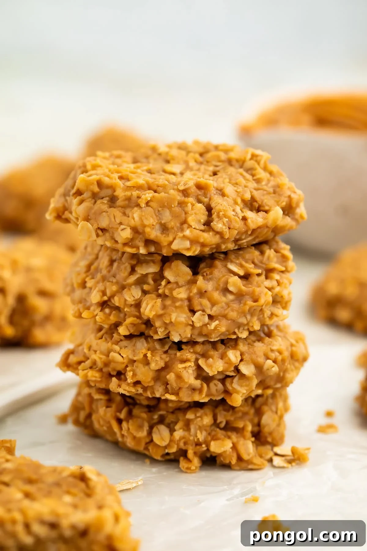 Stack of no bake peanut butter oatmeal cookies on a piece of wax paper.