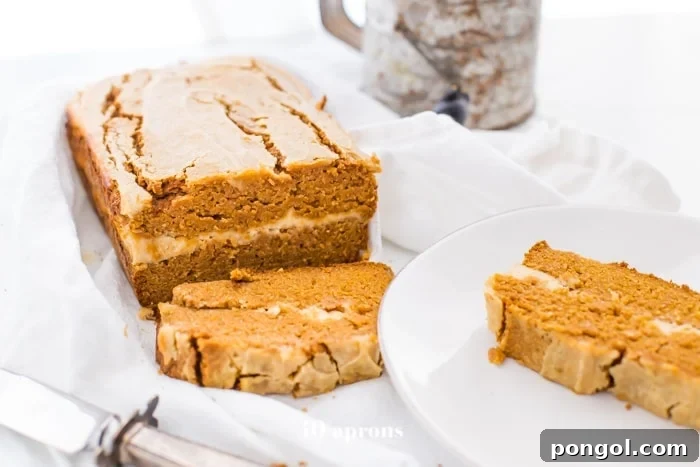 Paleo pumpkin bread with cream cheese swirl sliced with one piece on a plate