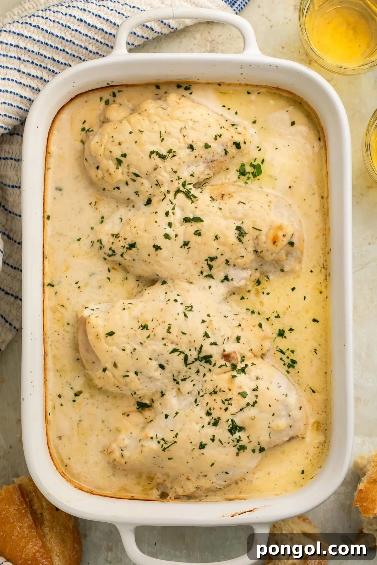 Creamy ranch chicken baked in a white dish, garnished with fresh parsley.