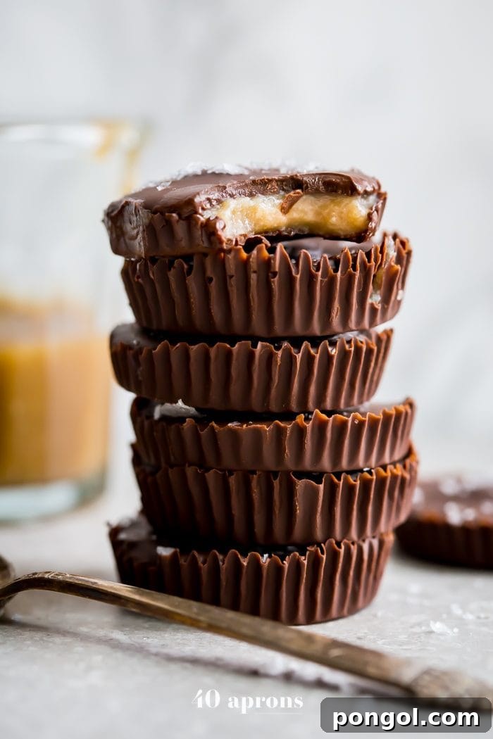 A close-up of a Paleo Chocolate Cup with Caramel, showing the smooth chocolate exterior and a peek of the golden caramel filling. A healthy, dairy-free treat.