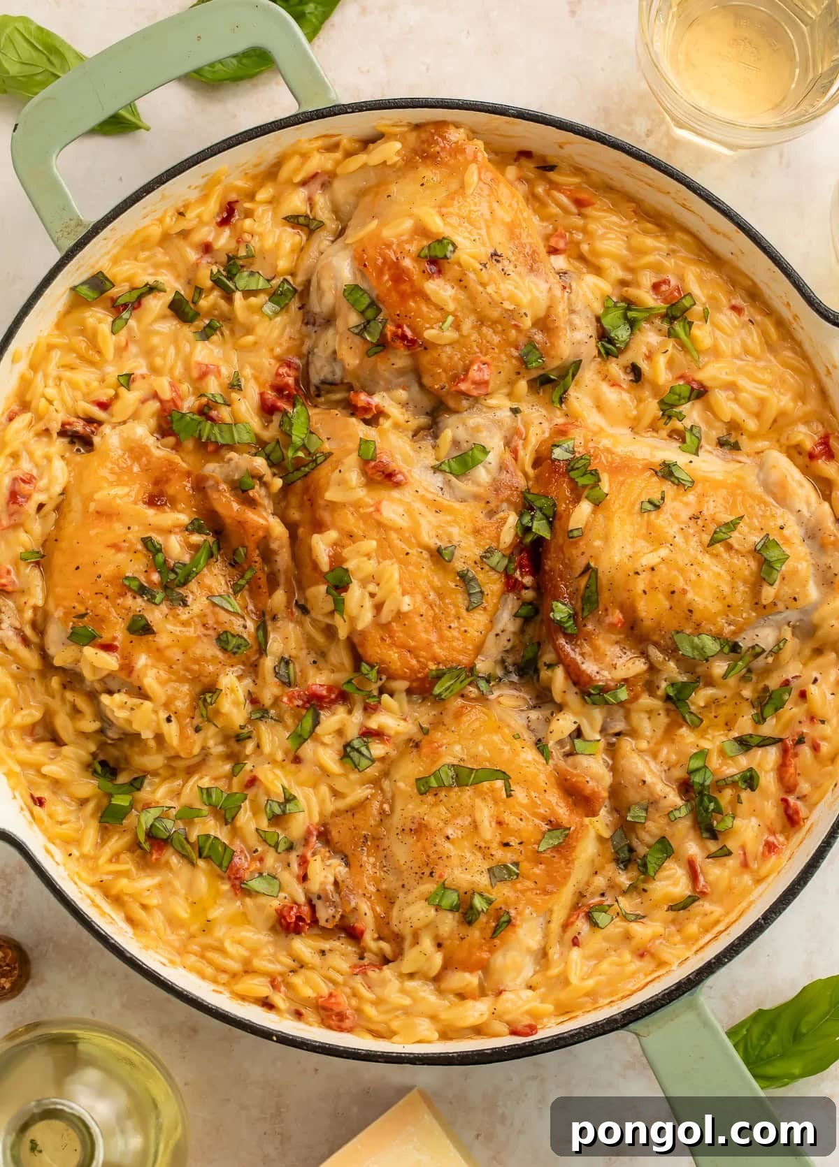Marry me chicken and orzo skillet with golden chicken thighs in creamy sauce garnished with fresh basil