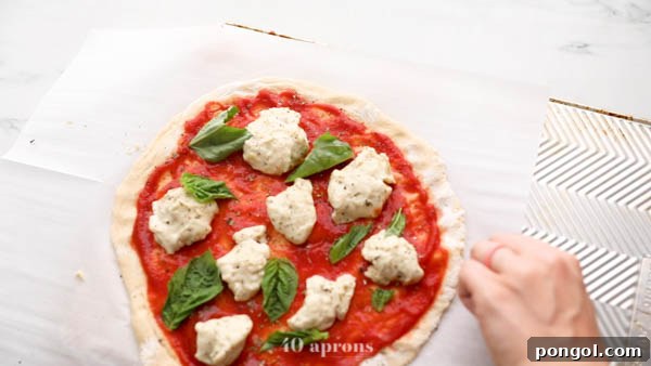 Sliding prepared paleo pizza onto an overturned baking sheet