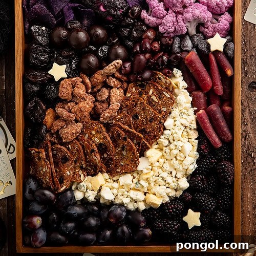 Halloween themed charcuterie board in wooden tray featuring purple and black foods arranged with star cheese cutouts