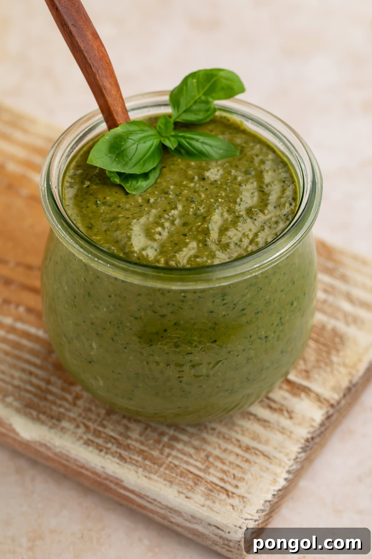Close-up view of creamy pesto sauce showing texture in glass jar