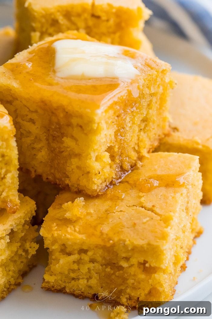 Close-up of moist gluten-free cornbread with honey and butter melting into golden crumb