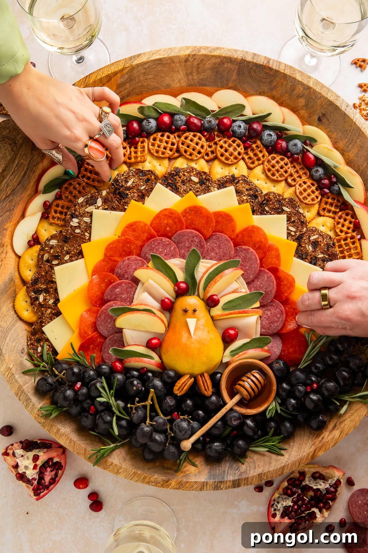 Hands reaching for Thanksgiving turkey charcuterie board with fresh cranberries and blueberries, illustrating its irresistible appeal as a holiday appetizer.