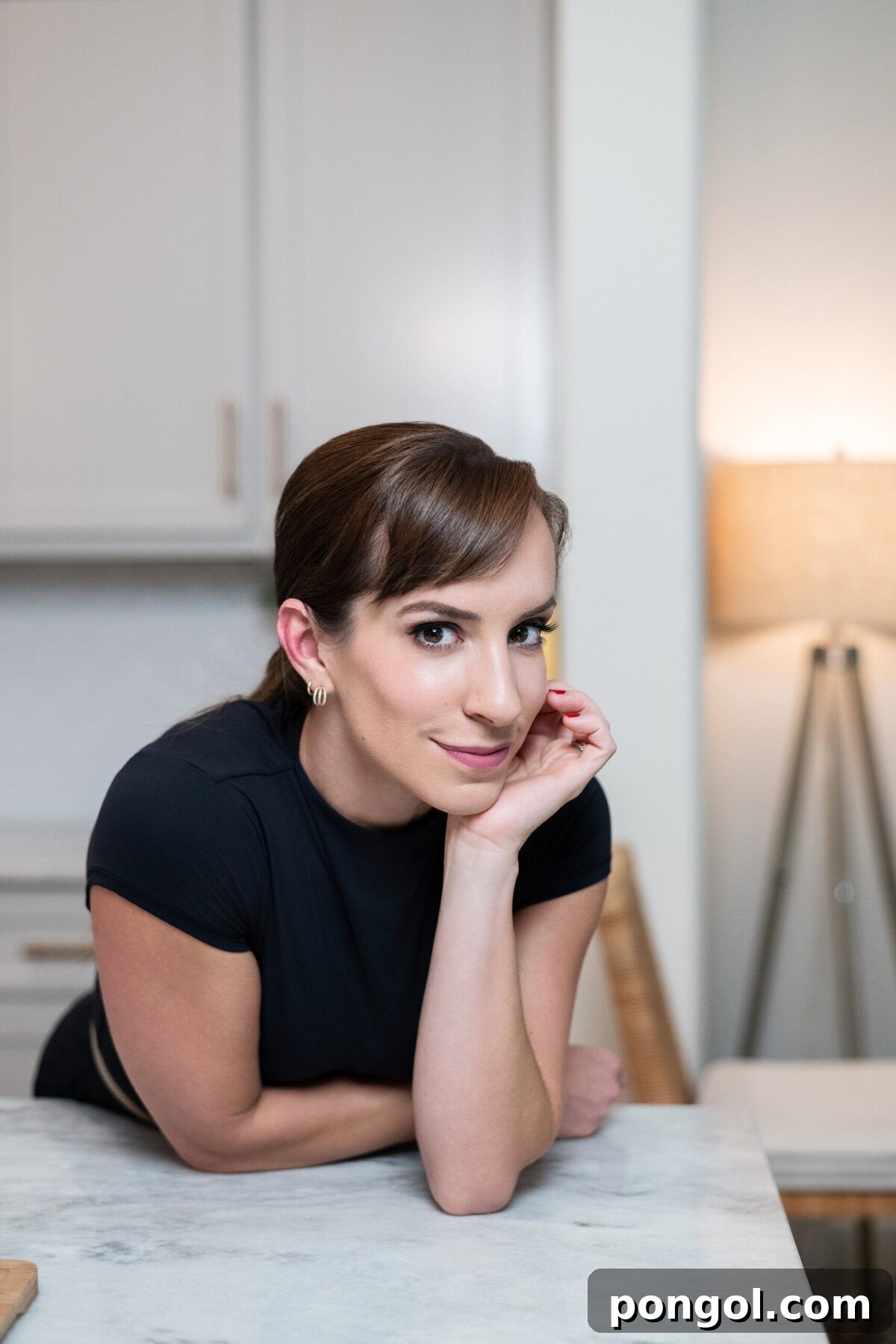 Portrait of a woman leaning on a kitchen counter, featured as part of a Black Friday gift guide.