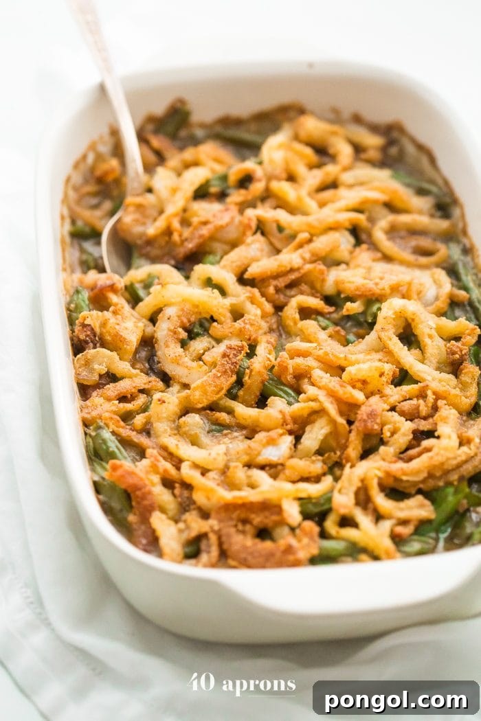 A beautifully presented Whole30 green bean casserole, featuring vibrant green beans coated in a creamy mushroom sauce and topped with golden, crispy fried onions. This healthy, paleo-friendly version is perfect for Thanksgiving celebrations, free from grains and dairy.