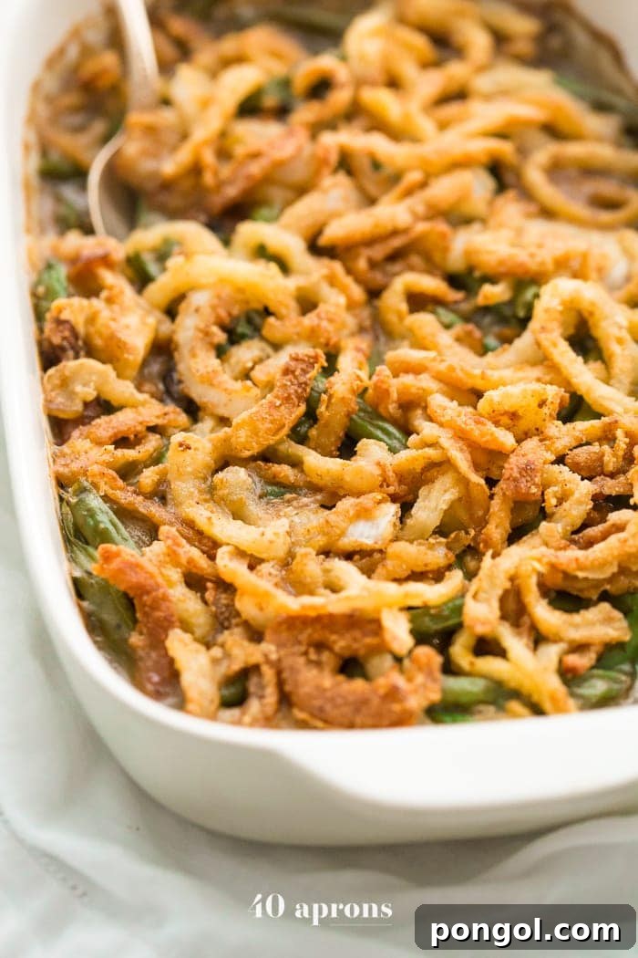 A side view of the Whole30 green bean casserole, showcasing its layers of tender green beans, rich creamy sauce, and golden crispy onions. This healthy, dairy-free version of the Thanksgiving classic is sure to impress.