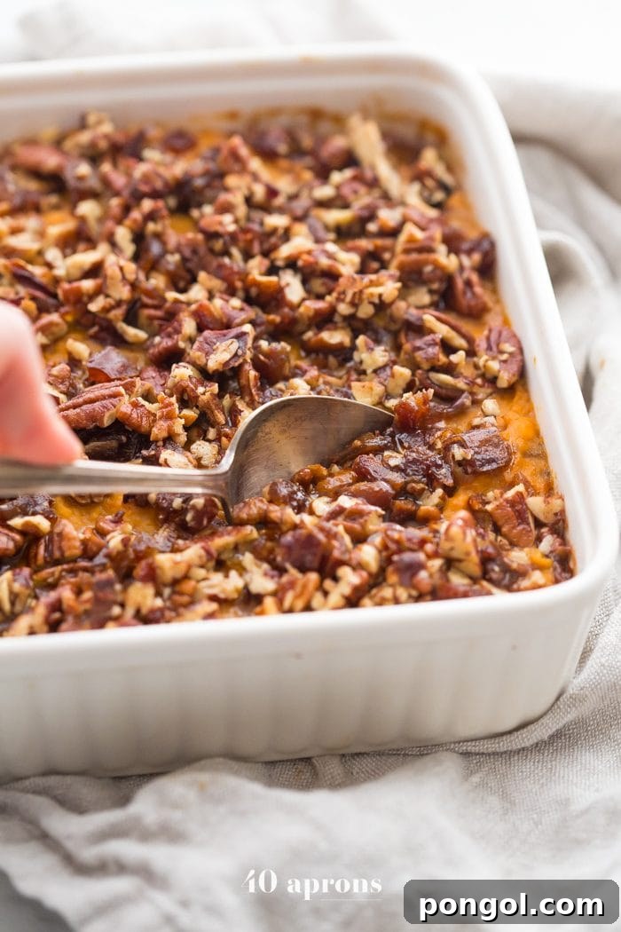 A serving of Whole30 sweet potato casserole, showing the crisp pecan-date topping and creamy sweet potato.
