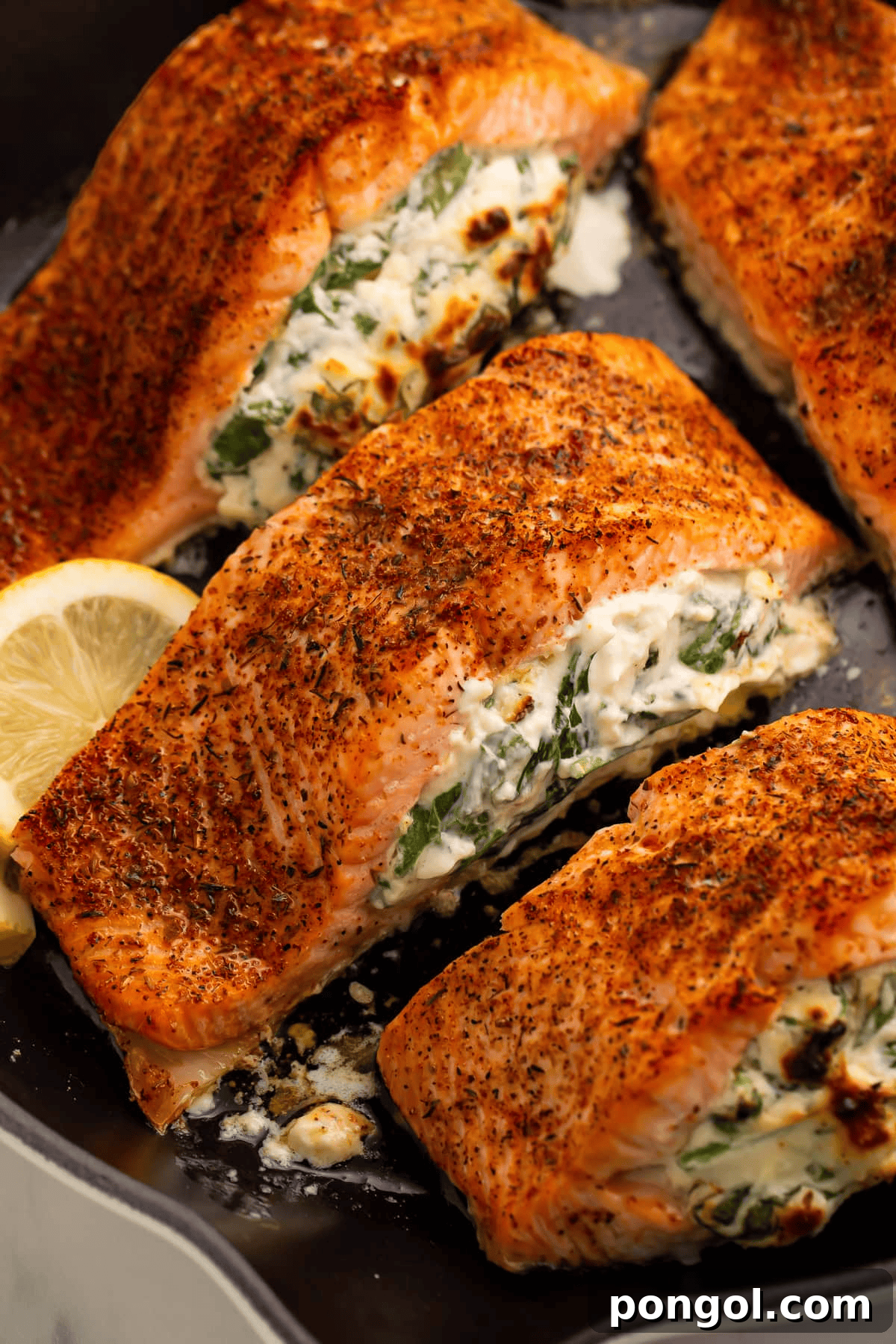 Baked stuffed salmon fillets, generously filled with a creamy, savory mixture of cream cheese, garlic, Parmesan, and spinach, baked to golden perfection