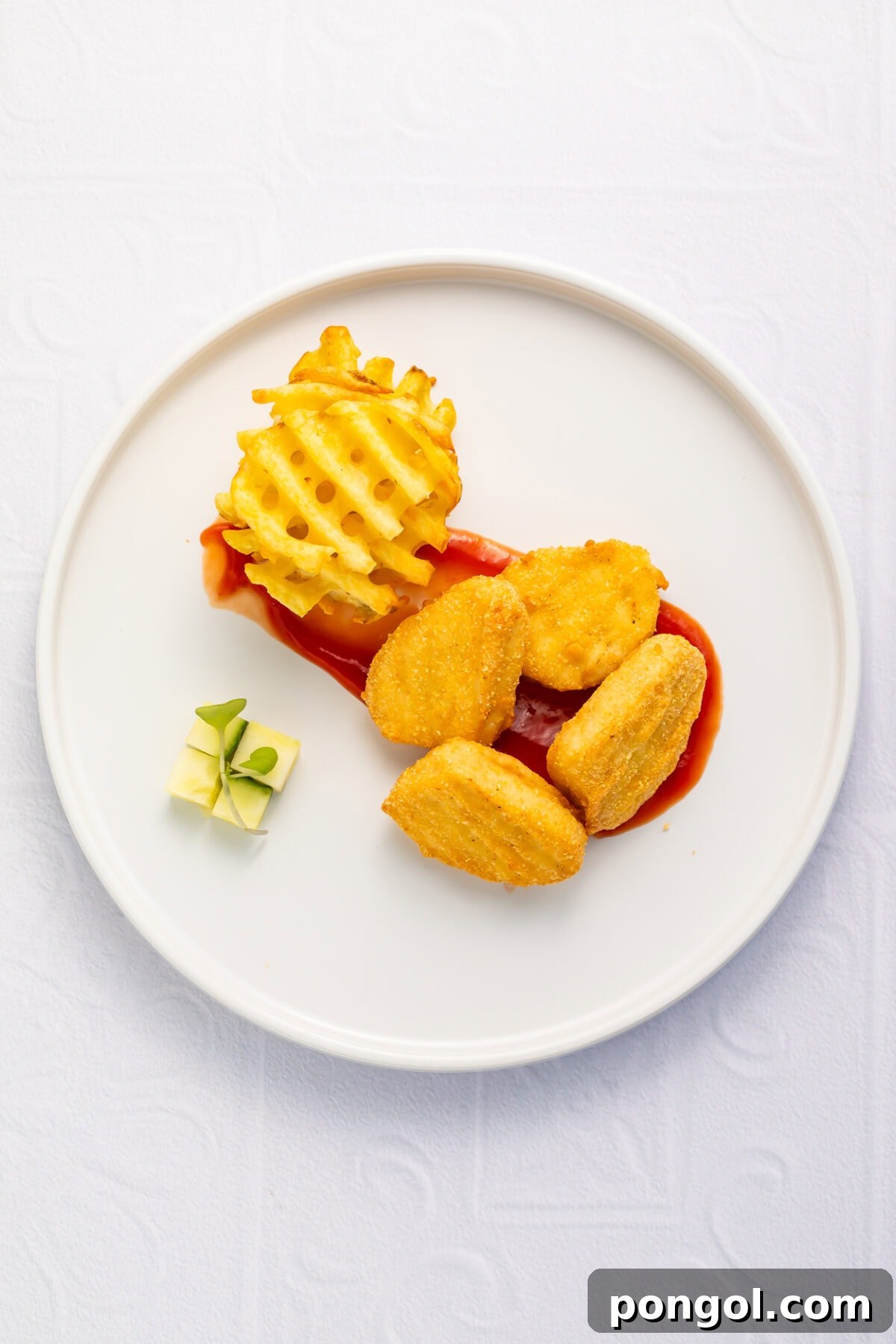 Little Loves' Valentine's Day Feast 7 Crispy chicken nuggets arranged domino-style over a ketchup brushstroke, with a stack of waffle fries and a cheese cube garnish