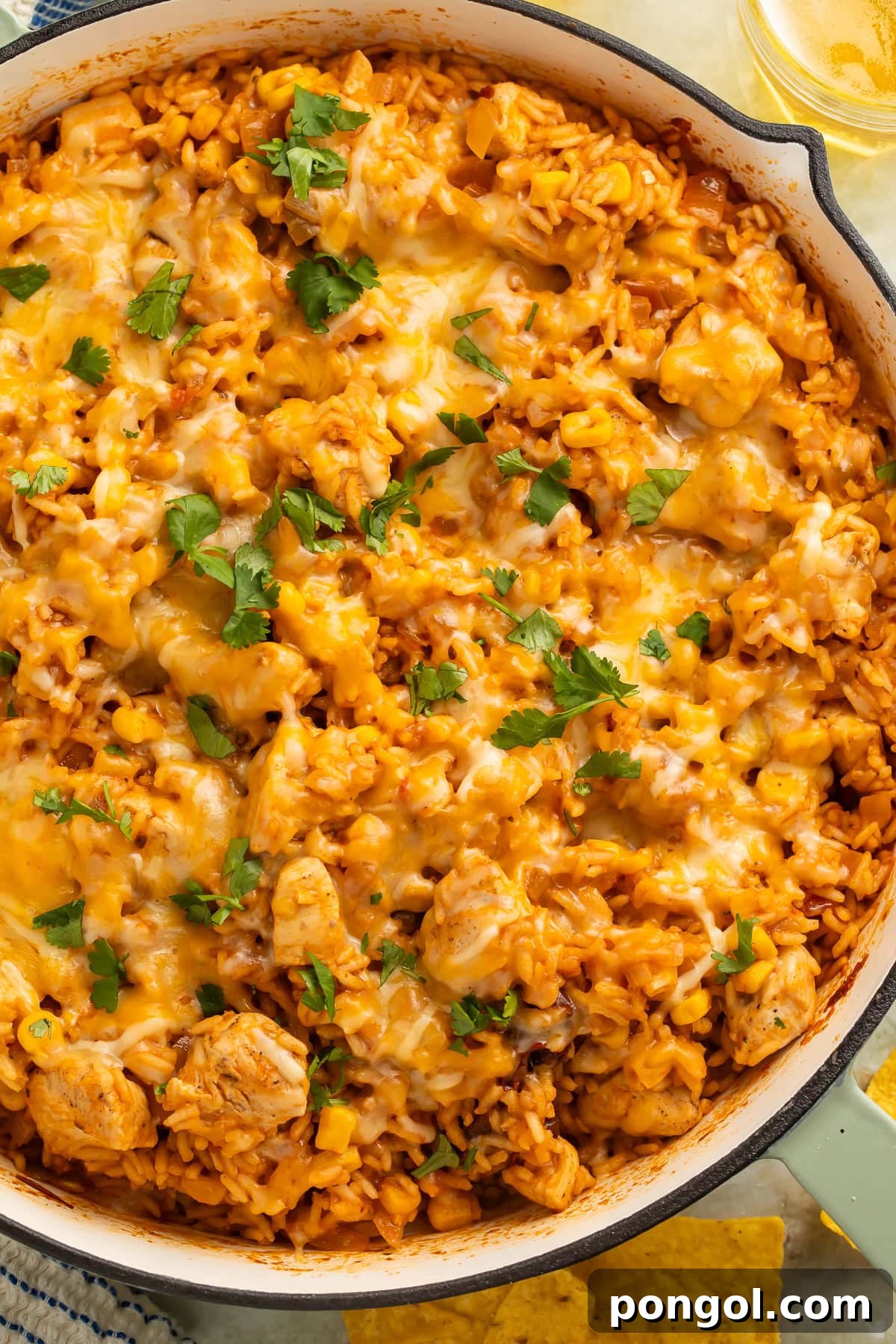 Close-up of cheesy one pan Mexican chicken and rice with melted cheese and fresh cilantro.