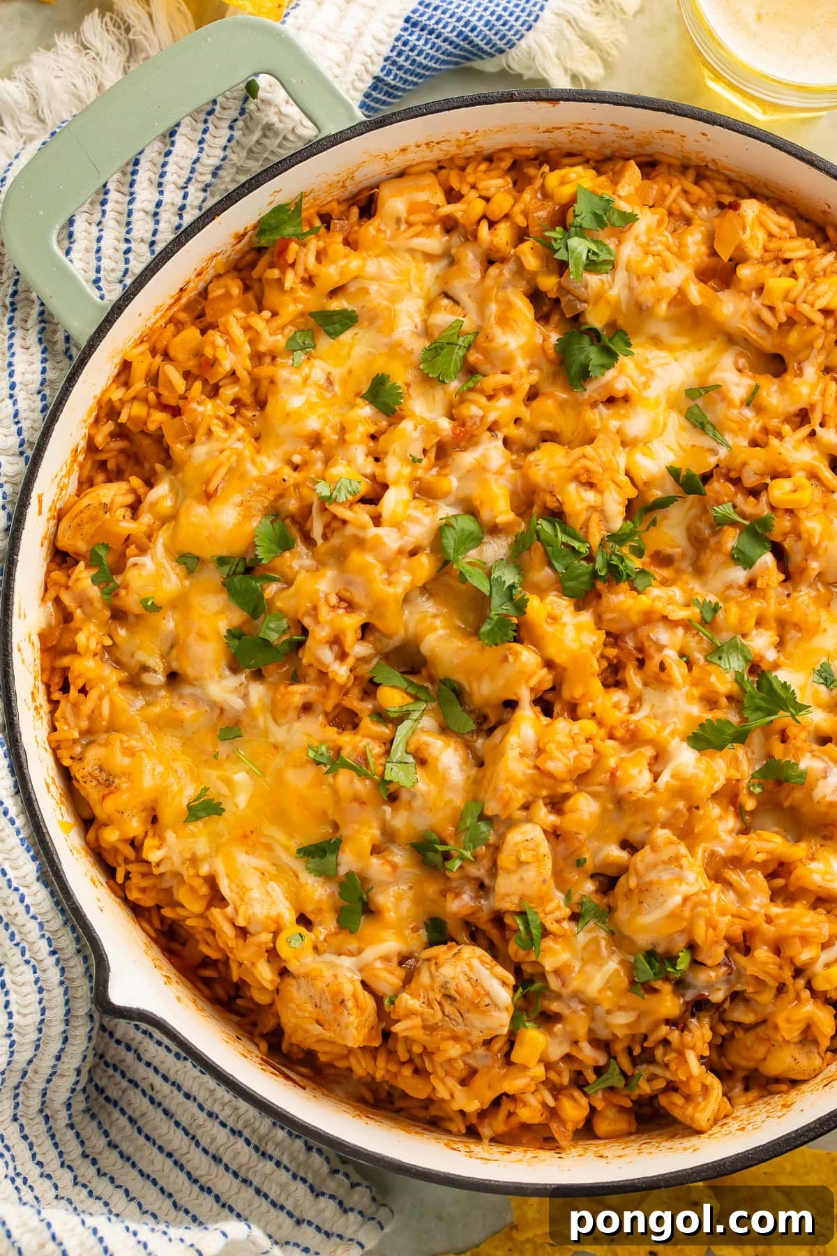 Cheesy Mexican chicken and rice skillet with corn, melted cheese, and chopped cilantro on top. 