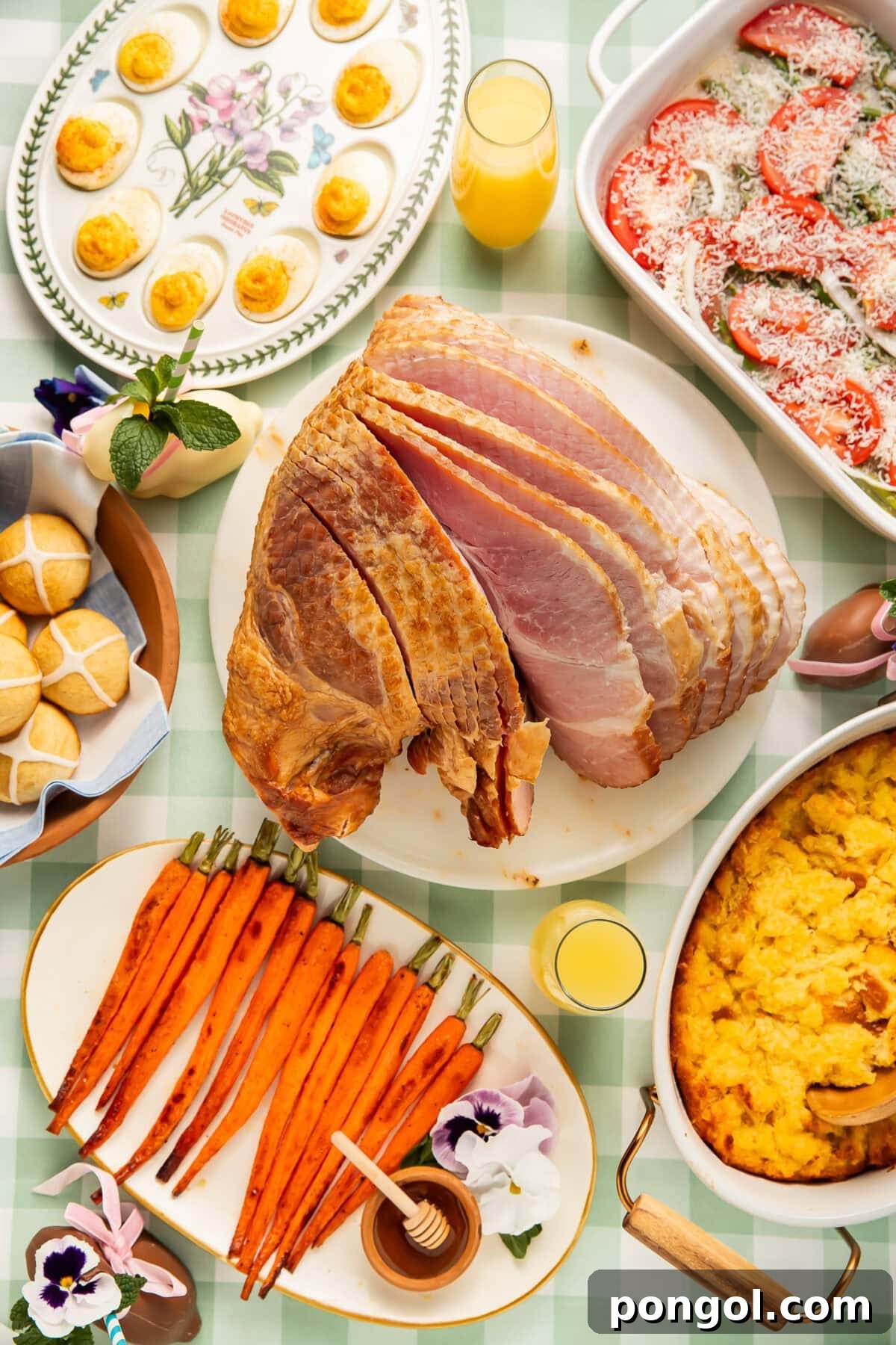 Easter Feasts Gifts and Fun Your Complete Celebration Guide 11 Overhead view of an Easter dinner spread with spiral ham, deviled eggs, roasted carrots, hot cross buns, and casserole dishes on a green gingham tablecloth, embodying traditional holiday warmth.