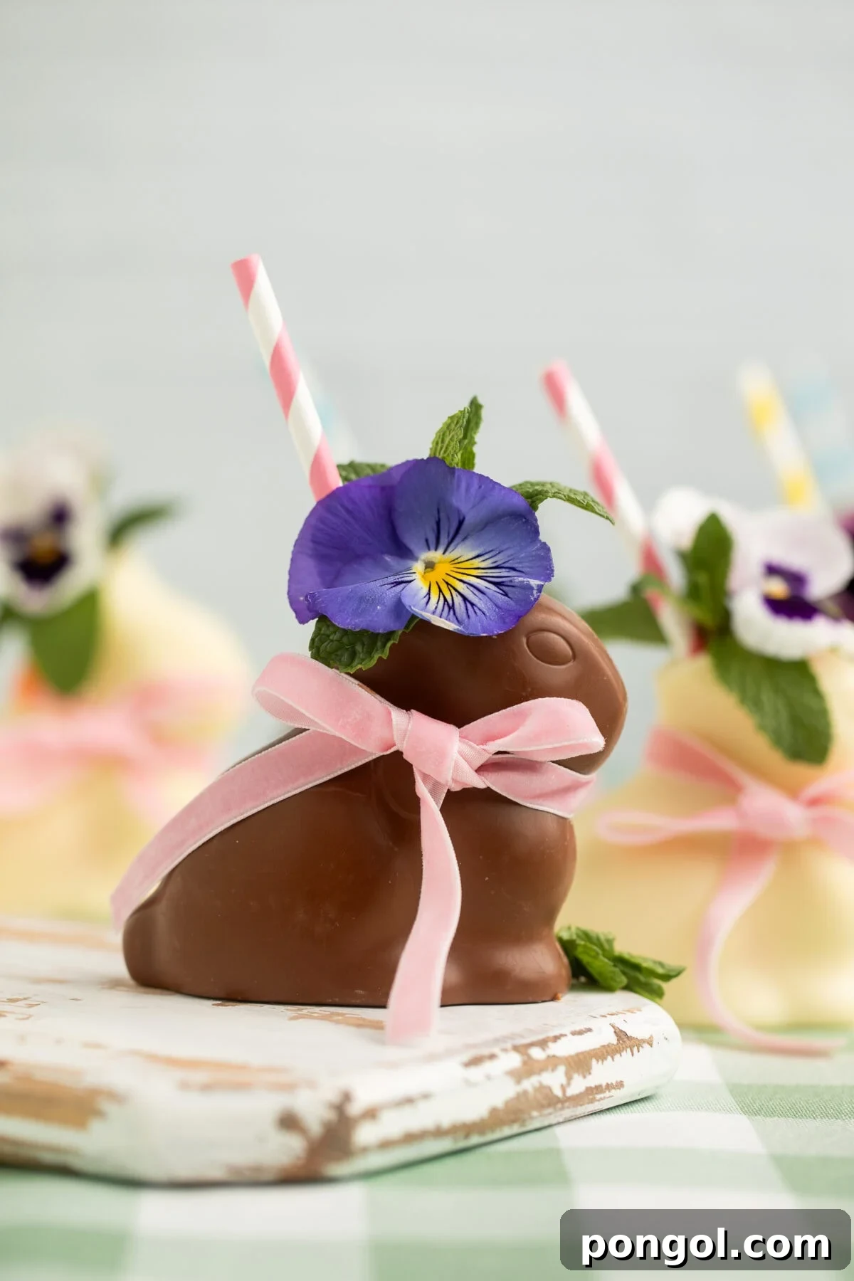 Easter Feasts Gifts and Fun Your Complete Celebration Guide 13 A hollow chocolate bunny serving as a unique cocktail glass, filled with a creamy drink and garnished with a purple pansy, fresh mint, and a pink striped straw, a whimsical Easter treat.