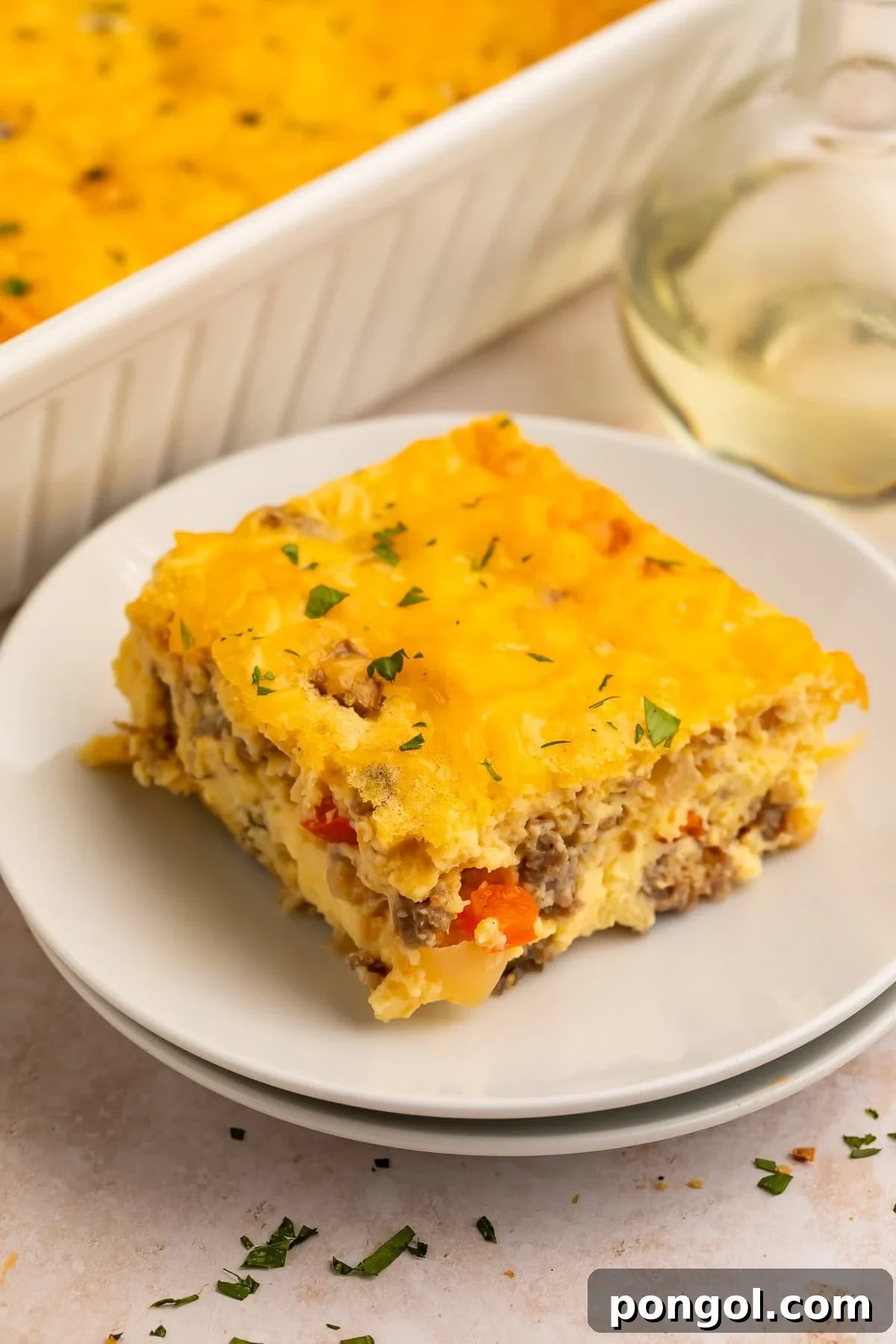 Easter Feasts Gifts and Fun Your Complete Celebration Guide 3 A square slice of cottage cheese egg bake with melted cheddar and parsley on a white plate, ready for an Easter brunch.