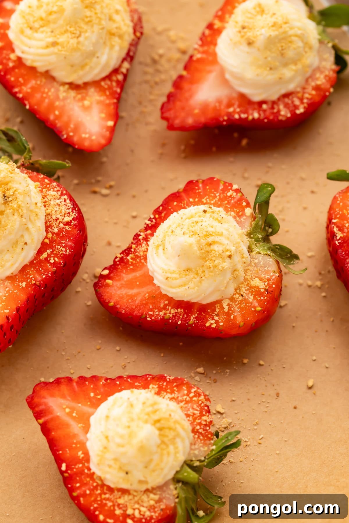 Easter Feasts Gifts and Fun Your Complete Celebration Guide 6 Close-up of deviled strawberries with piped cream cheese filling and graham cracker crumbs on parchment paper, a sweet and festive Easter treat.