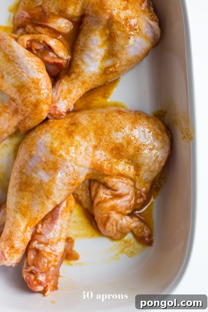 Nourishing Indian Saag Chicken Whole30 Paleo 4 Indian-spiced chicken marinating in a bowl, ready for cooking