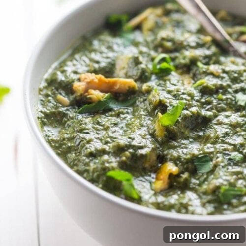 Nourishing Indian Saag Chicken Whole30 Paleo 7 A hearty serving of Whole30 Indian Saag Chicken in a white bowl, garnished with fresh cilantro.