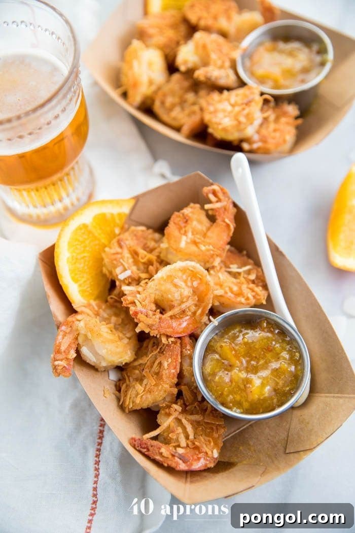 Tangy Orange Coconut Shrimp for Whole30 and Paleo 2 Whole30 coconut shrimp with orange sauce in a container