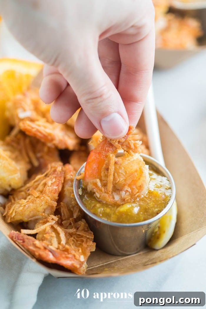 Tangy Orange Coconut Shrimp for Whole30 and Paleo 3 Whole30 coconut shrimp with orange sauce in a container