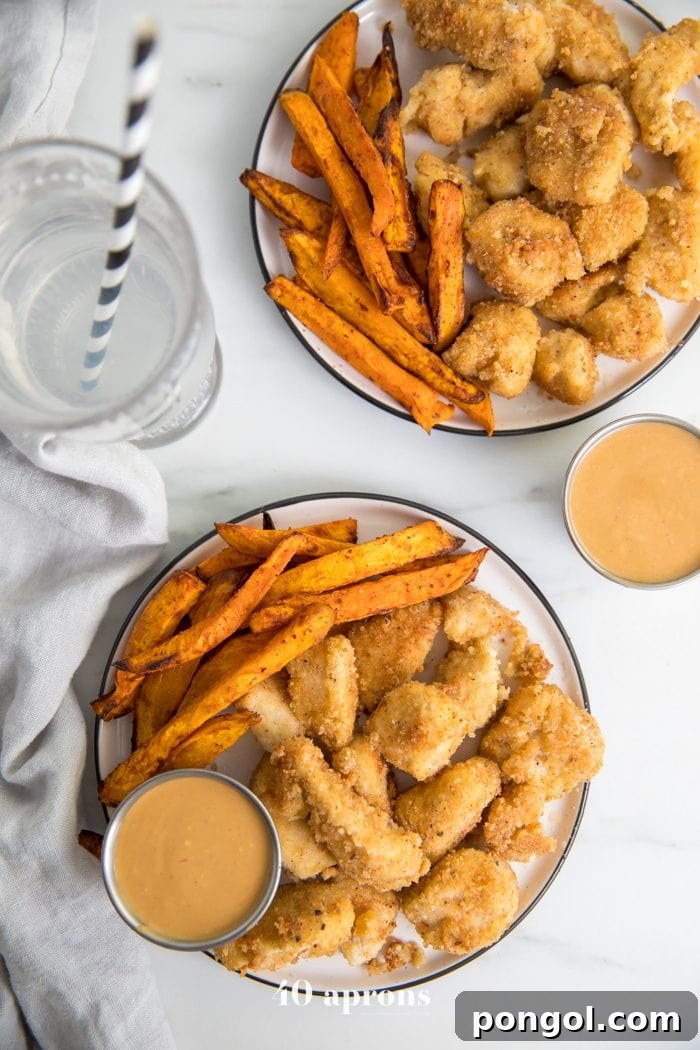 Paleo Whole30 chicken nuggets recipe on a plate with dipping sauce and sweet potato fries