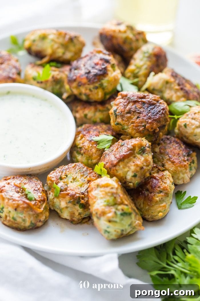 Hand scooping out Whole30 Chicken Bacon Ranch Poppers mixture using a meatball scooper, showcasing the texture before cooking.