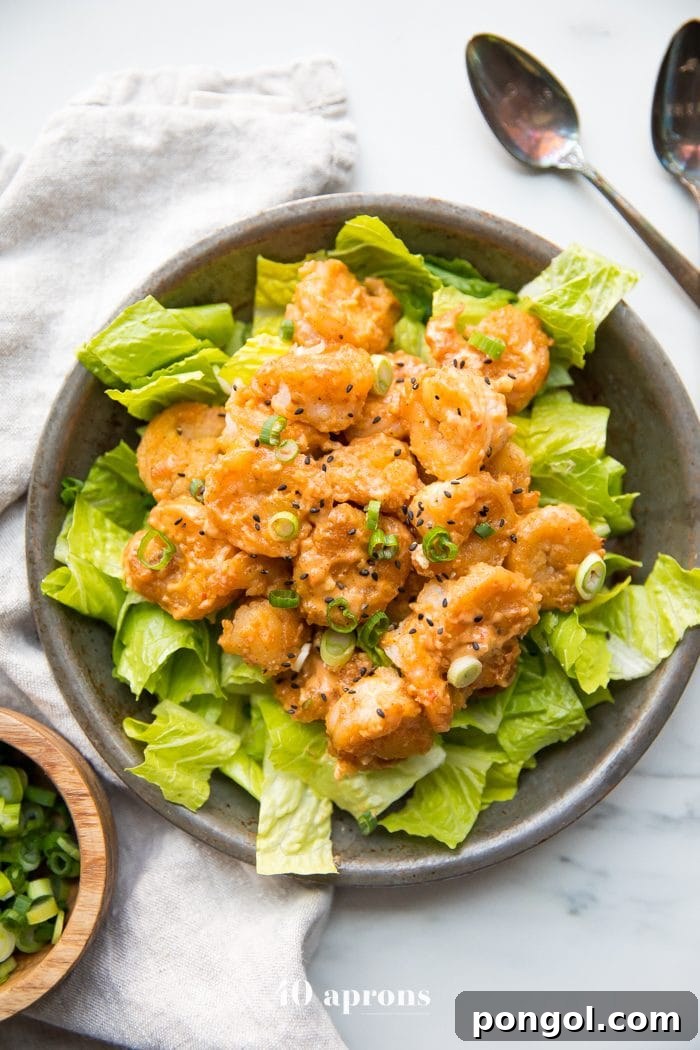 Crispy Whole30 bang bang shrimp on a bed of fresh romaine lettuce