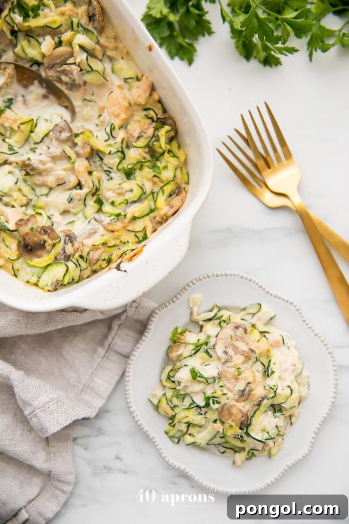 Whole30 Zoodle Tuna Bake 3 Whole30 tuna zoodle casserole served on a plate, highlighting the creamy sauce and fresh ingredients. A full casserole dish sits in the background.