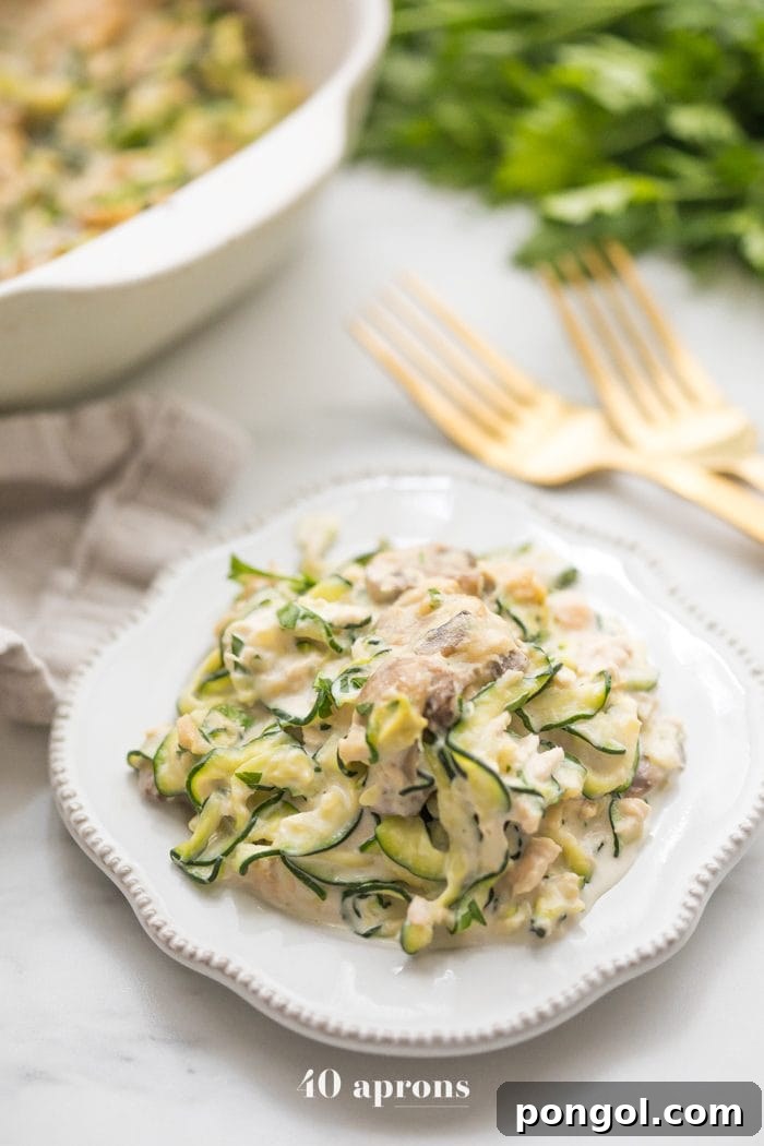 Whole30 Zoodle Tuna Bake 4 A serving of Whole30 tuna zoodle casserole on a plate, showing a close-up of the rich, creamy sauce, zoodles, mushrooms, and tuna.