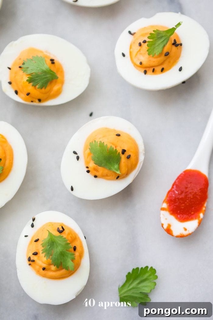Vibrantly spiced Sriracha Deviled Eggs garnished with cilantro, a perfect Whole30 and Paleo appetizer.
