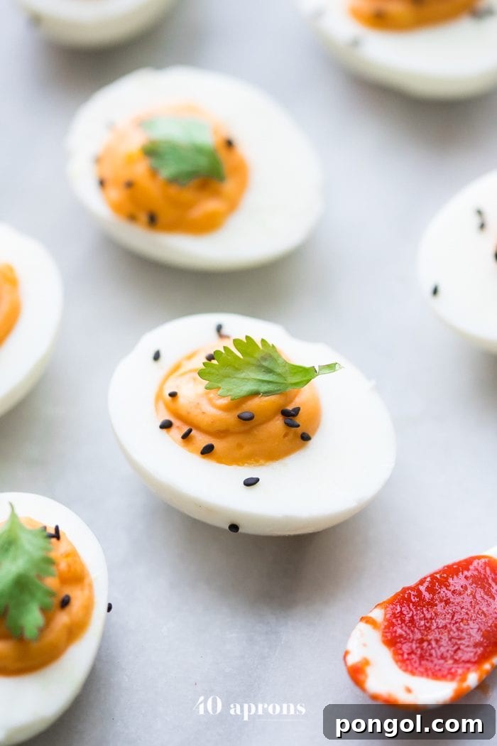 A close-up of a serving of spicy Sriracha Deviled Eggs, highlighting their creamy texture and inviting spice, suitable for Whole30 and Paleo diets.
