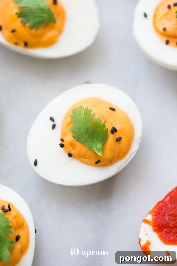 Delicious Sriracha Deviled Eggs presented on a platter, ready to be enjoyed as a Whole30 and Paleo compliant snack or appetizer.