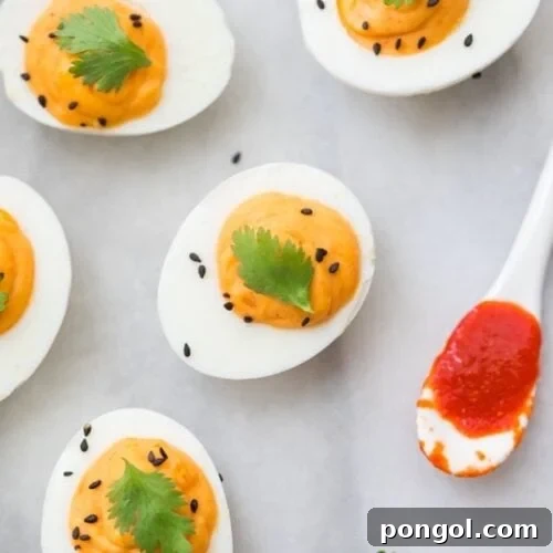 Whole30 sriracha deviled eggs with a spoon of Whole30 sriracha
