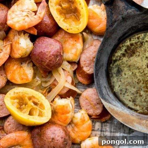 Whole30 shrimp boil with sausage, potatoes, and garlic ghee on newspaper