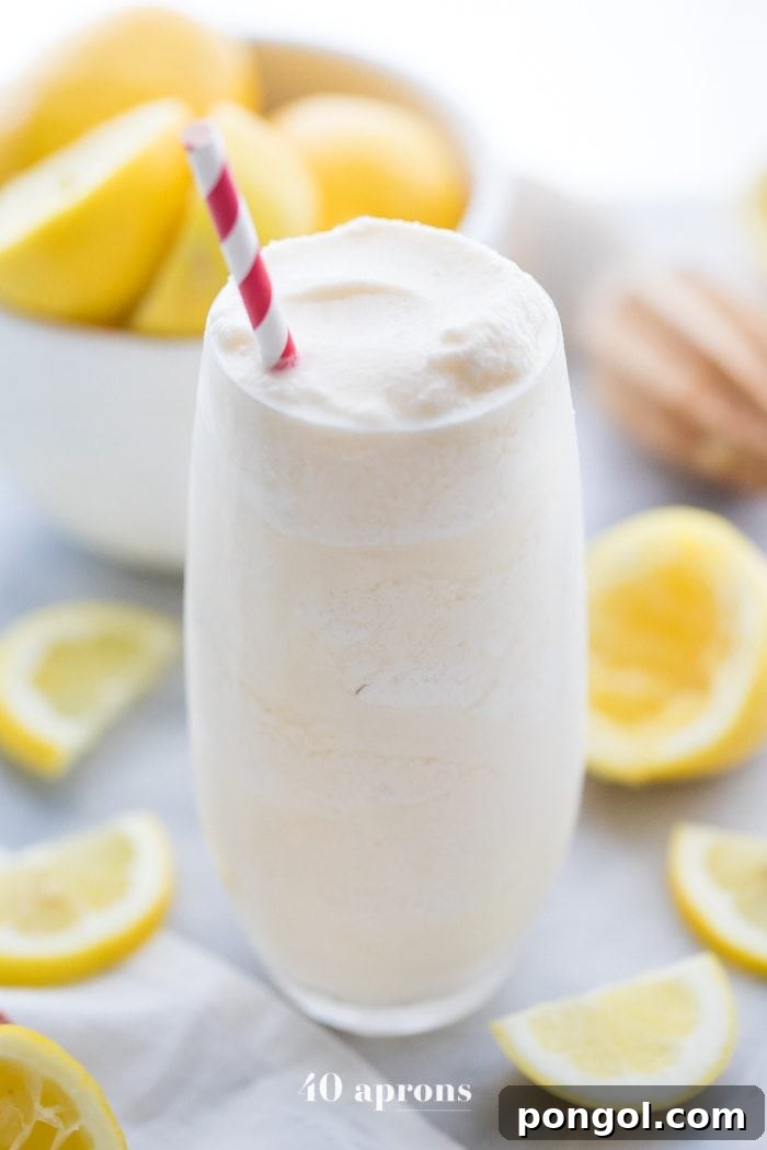 Healthy Chick Fil A frosted lemonade in a glass with a straw and lemons in the background