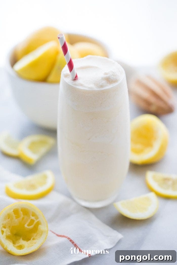 Healthy Chick Fil A frosted lemonade in a glass with a straw and lemons in the background