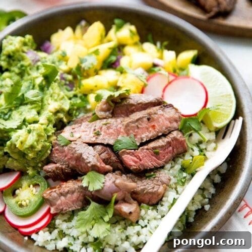 Whole30 Steak Taco Bowls: Tender steak, creamy guacamole, sweet pineapple salsa, quick pickled radishes, and cilantro-lime cauliflower rice for a healthy, low-carb Mexican dinner.