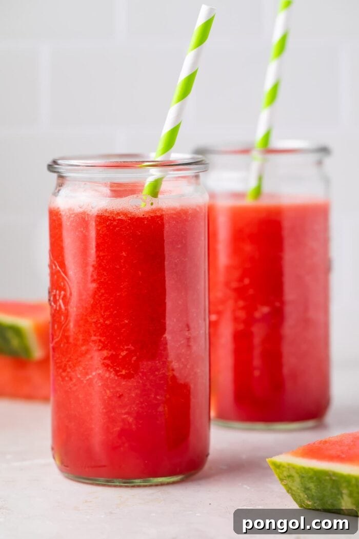 Two glasses of watermelon juice with green and white striped straws