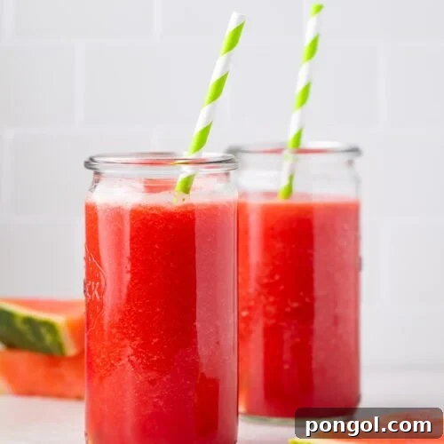 Zoomed out photo of two glasses of watermelon juice in front of slices of watermelon