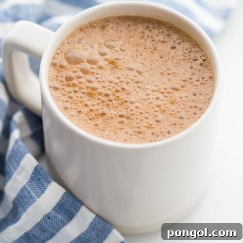 A mug of miracle maca latte with a blue-striped towel