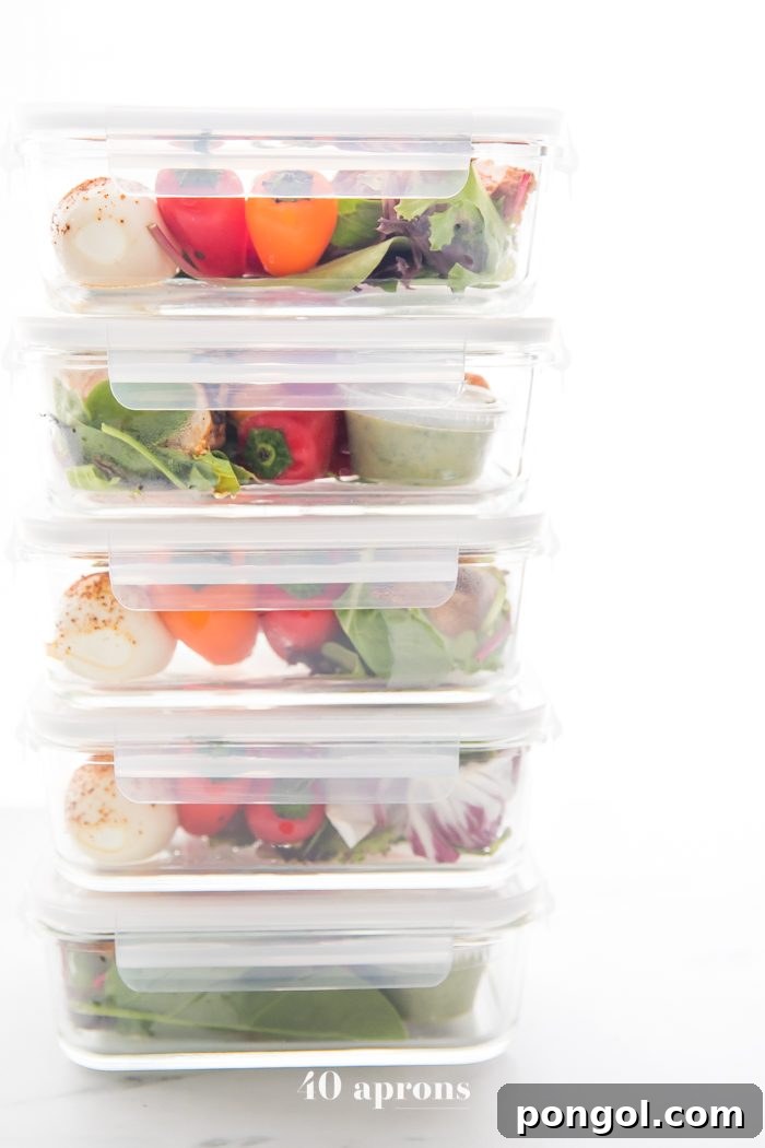 Stacked meal prep containers filled with healthy Mexican chicken, eggs, and vegetables