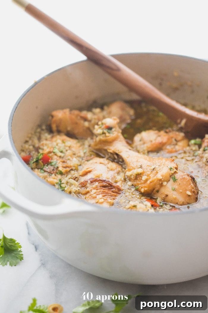 A large cooking pot filled with the healthy Spanish chicken and cauliflower rice stew, ready to be served. The stew is rich with chicken, vegetables, and cauliflower rice, indicating a satisfying and wholesome meal.