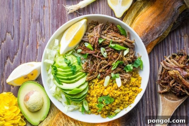 Wholesome Instant Pot Brisket Taco Bowls 2 Instant Pot Brisket Taco Bowl topped with avocado slices and chopped green onions placed on a rustic wooden tabletop.