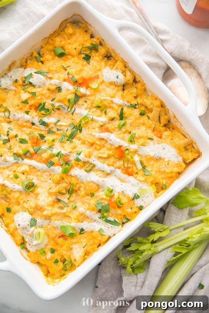 Paleo Buffalo Chicken Casserole in a white baking dish, garnished with fresh celery stalks on the side, ready to be served as a healthy, low-carb meal.