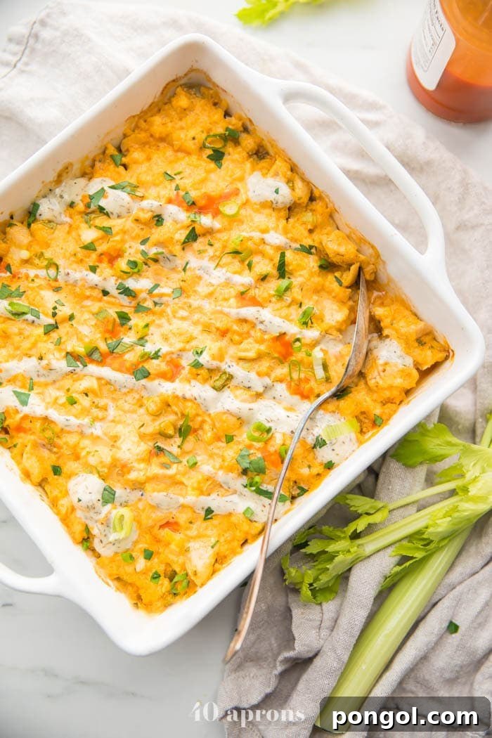 The assembled Paleo Buffalo Chicken Casserole mixture, before baking, evenly spread in a white baking dish, ready to be cooked to perfection.